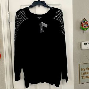 Long sleeve, black sweater, decked out from the shoulder to the mid arm, V-neck